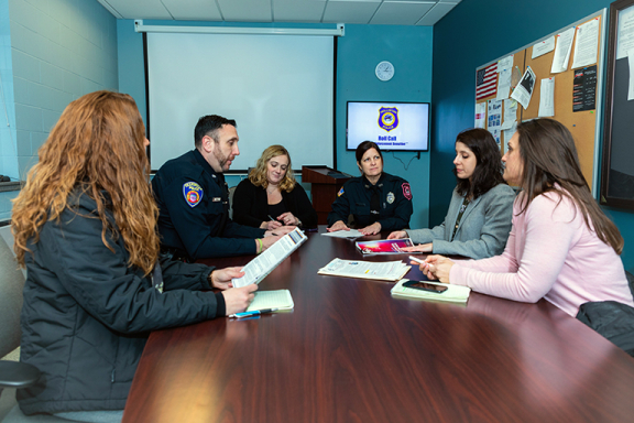 Advocates staff members sitting around a conference table with a police officer