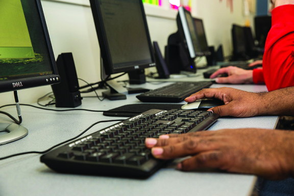 Closeup of person's hands using computer at Advocates Life Skills and Learning Center