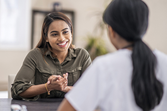 Smiling young woman speaking with a therapist.