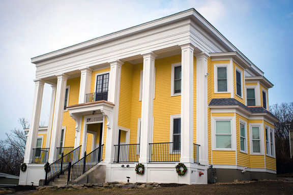 Exterior shot of Channing House, Advocates addiction recovery home for men. It is a large yellow house.
