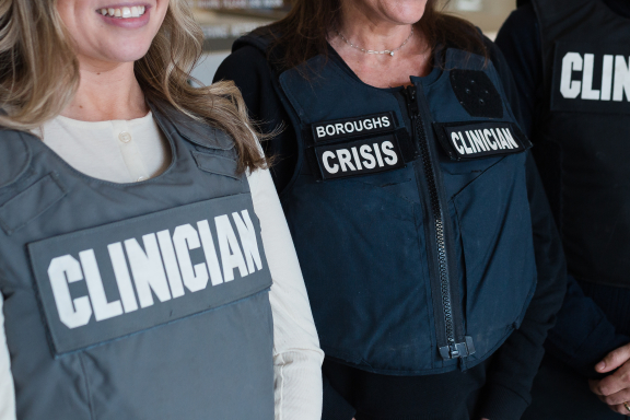 Three adults wearing police clinician vests.