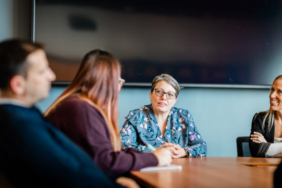 A group of adults sitting around a table having a conversation.