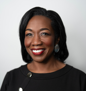 Smiling Black woman with shoulder length straight, dark hair and a black top.